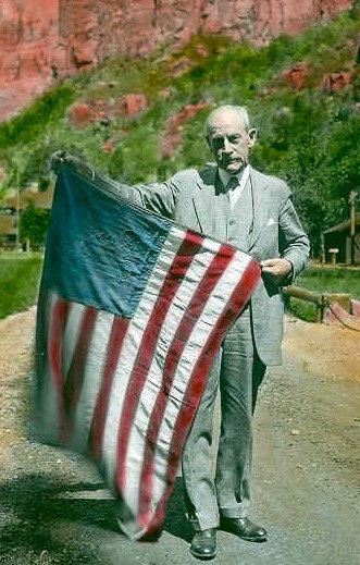 Frederick S. Dellenbaugh holding his US flag from the Powell Expedition of 1871-1872, at Zion Lodge Zion 1930, Zion Museum Collection ZION 13004-123