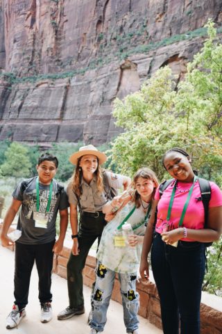 A group of students stand with a Zion National Park Ranger on a hiking trail.